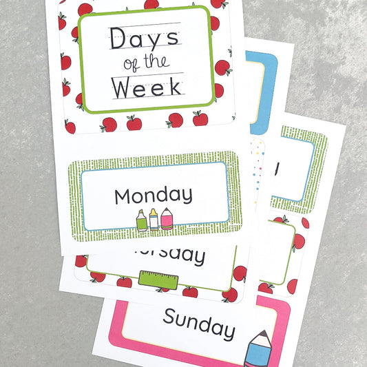 Educational cards with days of the week and apple illustrations on a grey surface