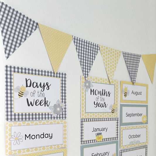 Yellow and grey educational posters and bunting flag displayed on white wall.