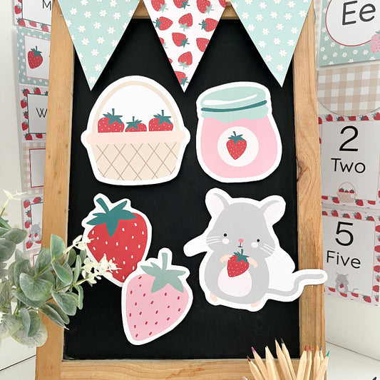 Decorative blackboard with strawberry-themed cut outs including a basket, jar, and mouse holding a strawberry.