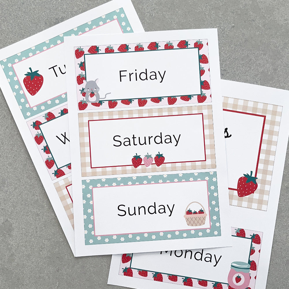 Set of days of the week cards with strawberry theme on a grey surface