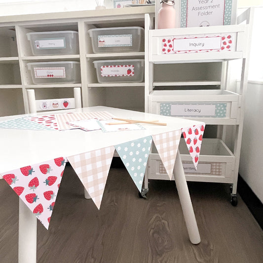 Educational setup with storage shelves, table, and bunting flags in a classroom.