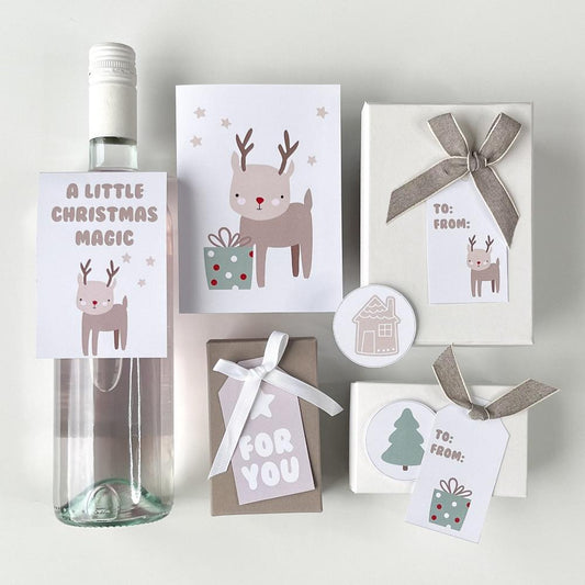 Cute Reindeer gift tags, wine label and greeting card displayed on gifts and displayed on a table.