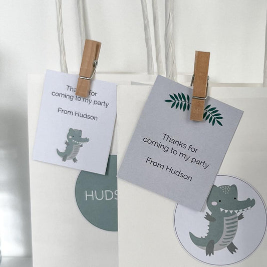 Gift tags pegged onto party bags in crocodile theme