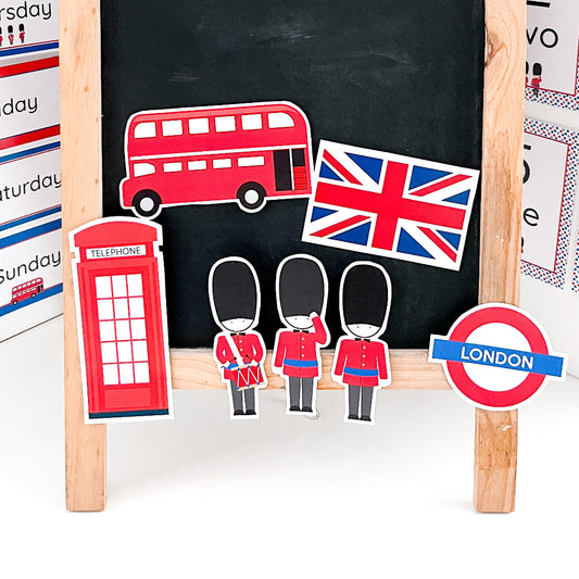 Educational display with London-themed items including a red double-decker bus, British flag, phone box, and London sign on a blackboard.