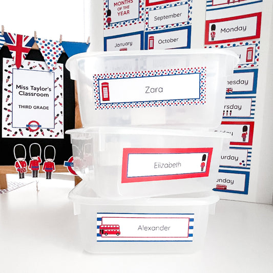 Educational classroom supplies with name labels on containers and a classroom sign.