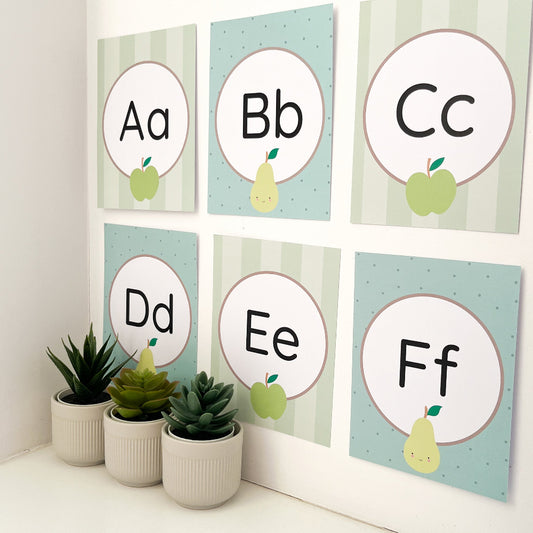 Alphabet posters with letters A to F on a light green background, with potted plants below.