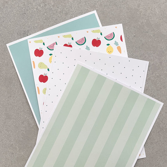 Three sheets of paper with different designs on a grey background