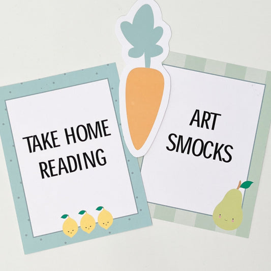 Two signs with text 'Take Home Reading' and 'Art Smocks' on a light gray background.