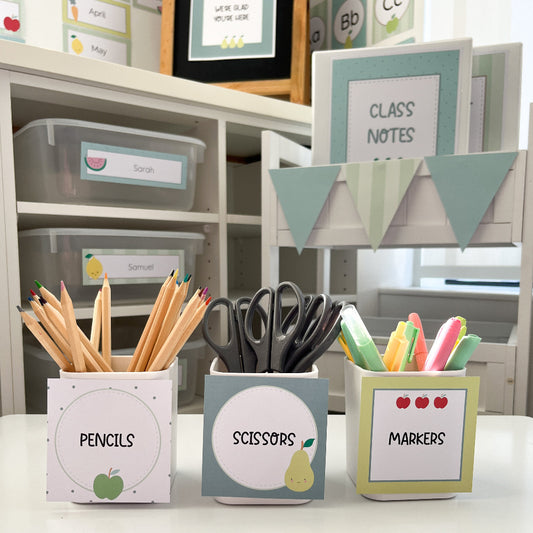 Stationery items including pencils, scissors, and markers in labeled containers on a shelf.