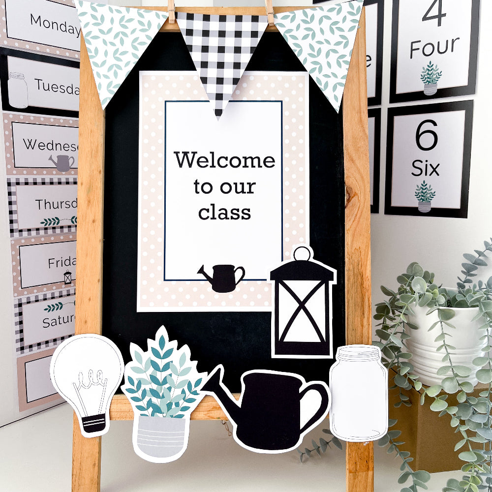 Classroom blackboard easel decorated with cut our shapes, a sign and bunting flag all in black, white and beige.
