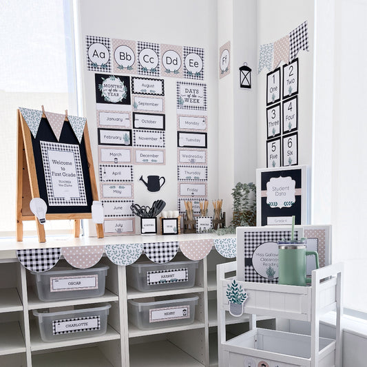 Farmhouse style classroom set up decorated in black, white and beige on white walls and benches.