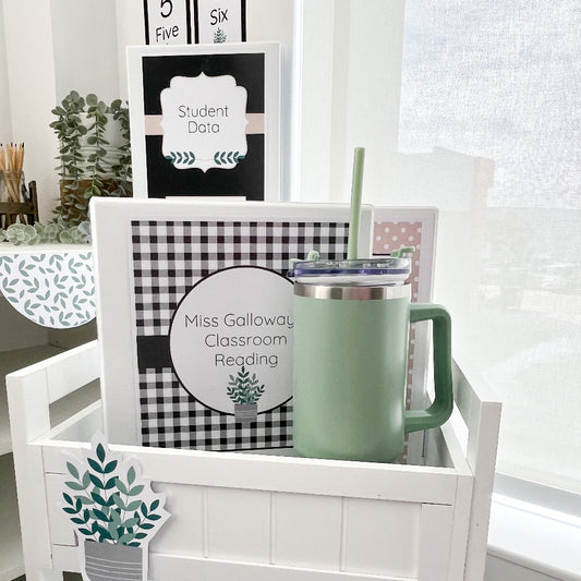 Green drink bottle with a straw and folders on a white teacher trolley with educational posters in the background.