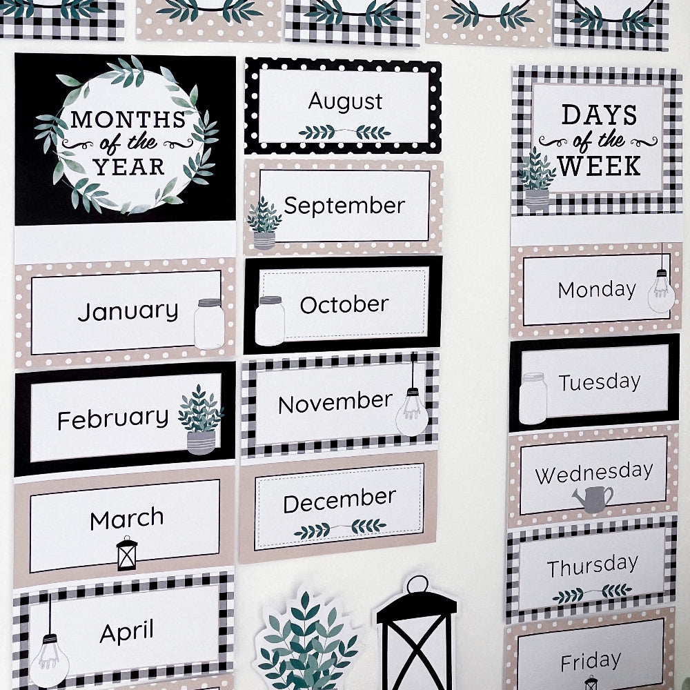 Classroom charts featuring Months of the Year and Days of the week displayed on a white wall. They are coloured in black, white and beige.