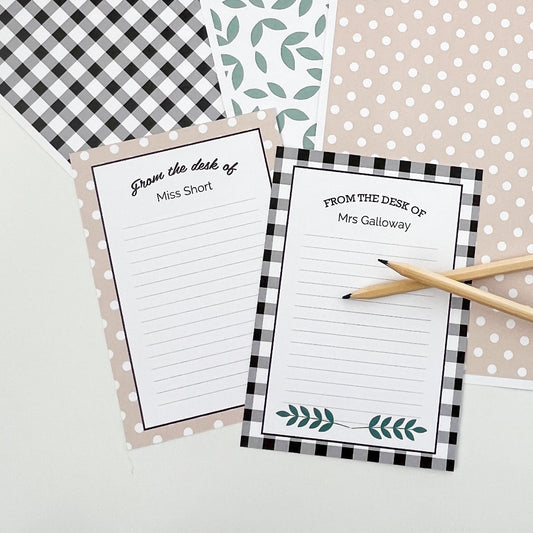 Two personalised notepads in a farmhouse theme with decorative borders on a patterned background