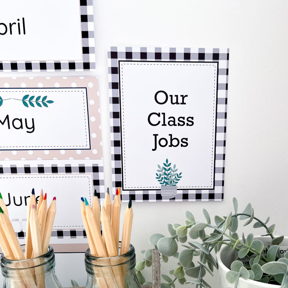 Small printable sign on white wall that says 'class jobs'. There is black gingham squares on the border and pencils in the foreground.