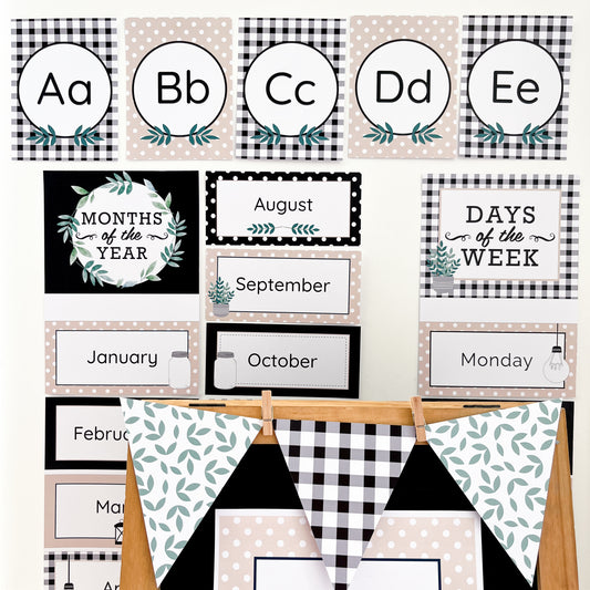 Educational posters with alphabet, months of the year, and days of the week on a white wall with a wooden board in the foreground.