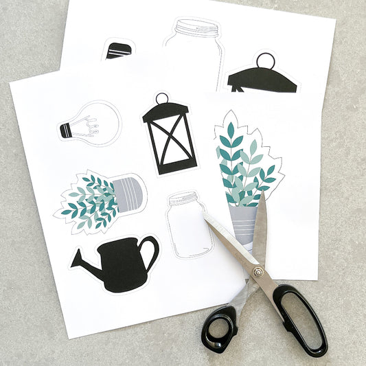 A pair if scissors is laid out on sheets of paper ready to cut out clip arts that would suit a farmhouse theme classroom.