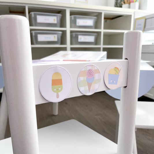 White chair with colorful ice cream-themed stickers on a wooden floor.