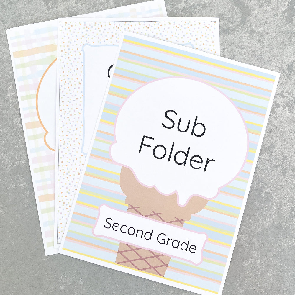 Two educational folders with decorative covers on a grey surface