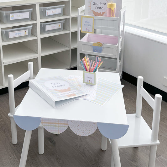 Children's table and chairs set with educational materials in a classroom setting.