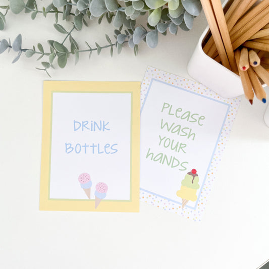 Two small signs on a surface with green leaves and wooden sticks in the background.