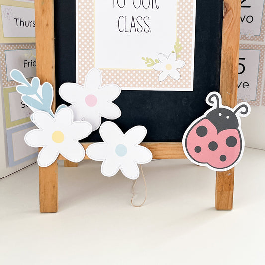 Decorative stand with flowers and a ladybug on a white surface