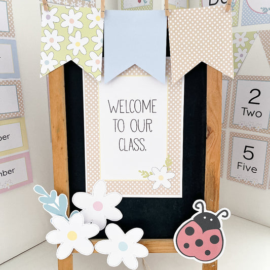 Decorative classroom sign with flowers and a ladybug, featuring text 'Welcome to our class.'