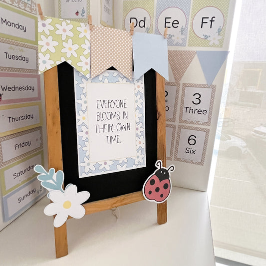 Children's educational board with decorative elements and text in a classroom setting.