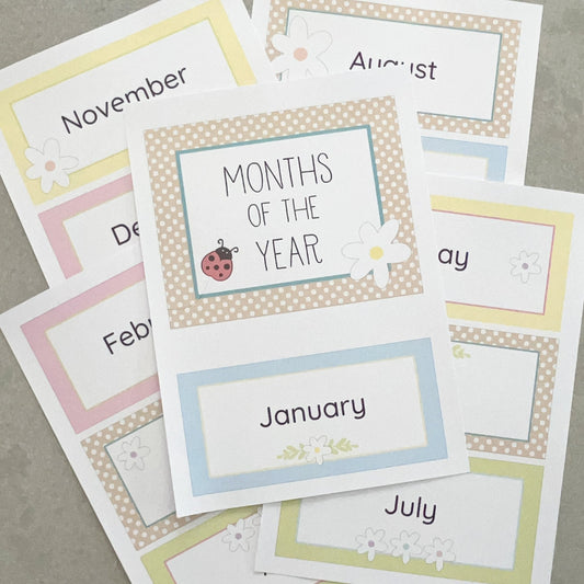 Pastel coloured educational cards with months of the year labels on a grey surface