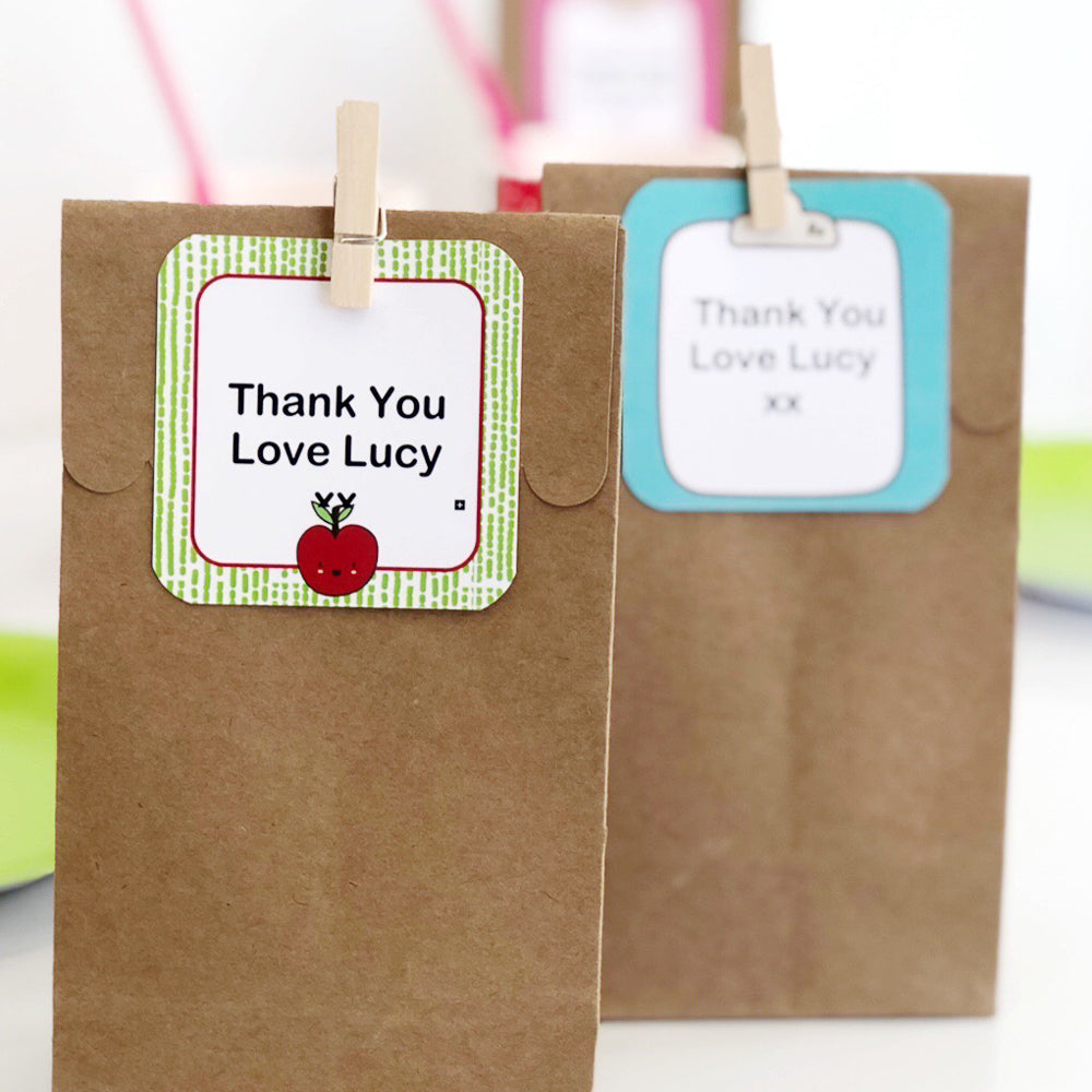 Bright school labels pegged onto brown party bags