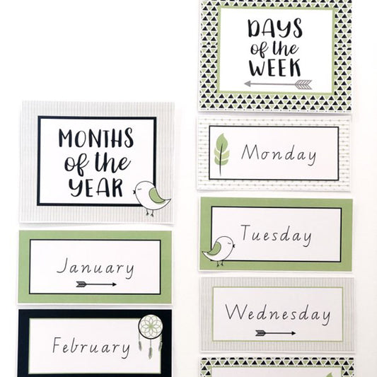 Classroom Months and Days charts in green, black and white on a white wall.