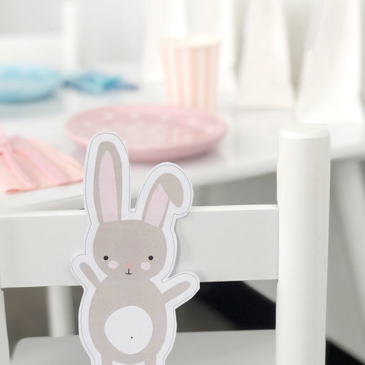 Cute Easter Bunny printable cut out and placed on chair in front of party table set up