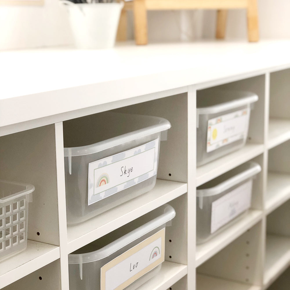Classroom locker tubs in cubby holes with rainbow themed name plates.