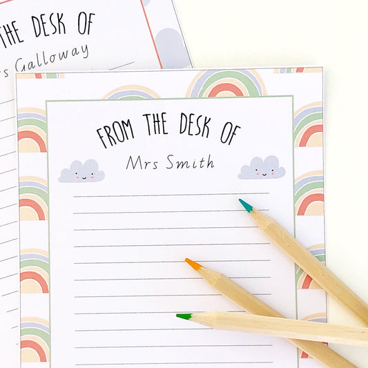 Printable note paper with a rainbow theme, with a pen on the side.