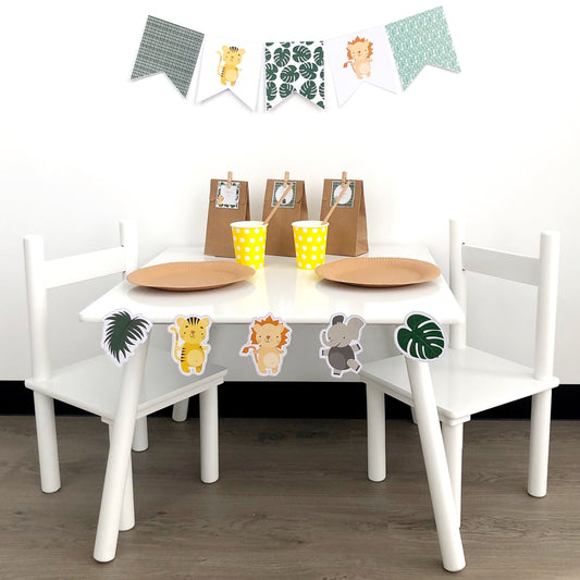 Safari themed part table set up with jungle leaves and cute lion, tiger and elephant shapes.