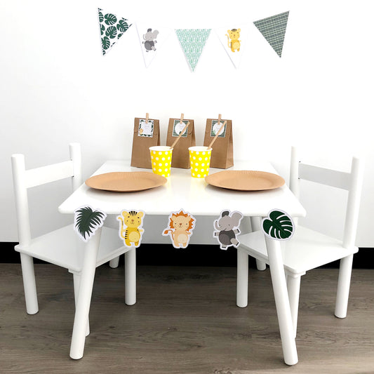 Safari themed part table set up with jungle leaves and cute lion, tiger and elephant shapes.