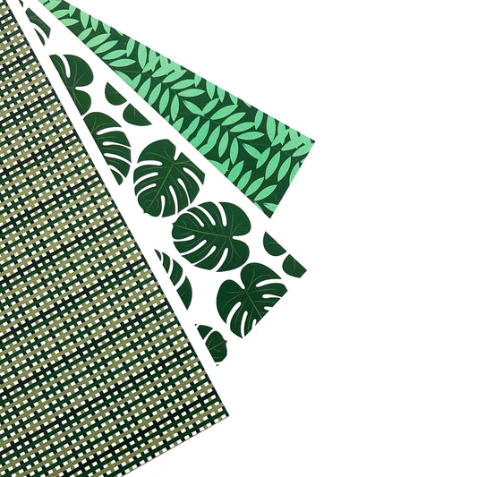 Three pieces of paper with green leaves and patterns displayed on white background