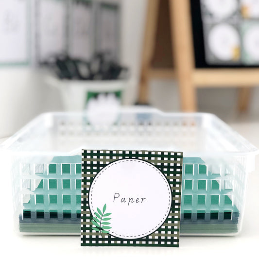 Paper displayed in a tray with a green classroom label featuring jungle leaves and a checked border
