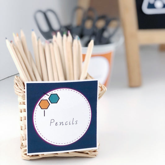 Basket of pencils with a navy square label featuring a science icon.