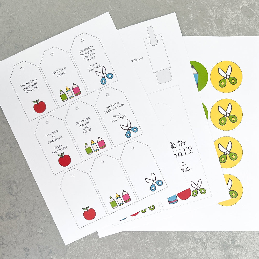 Printable gift tags with stationery icons and text on a grey surface