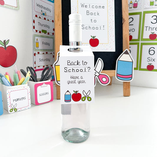 Clear bottle with a decorative label on a desk with school supplies and classroom decor.