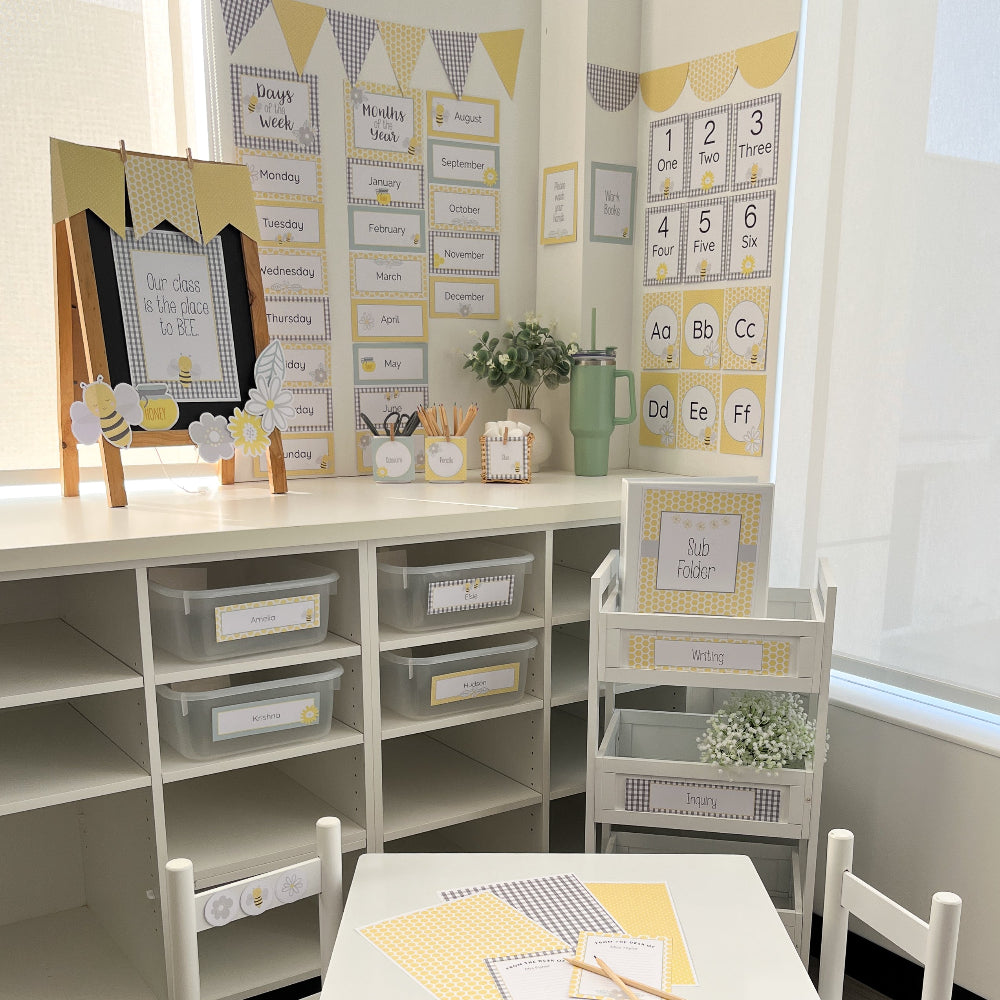 Yellow and Grey bee themed Classroom setup with educational materials and decor on a white desk.