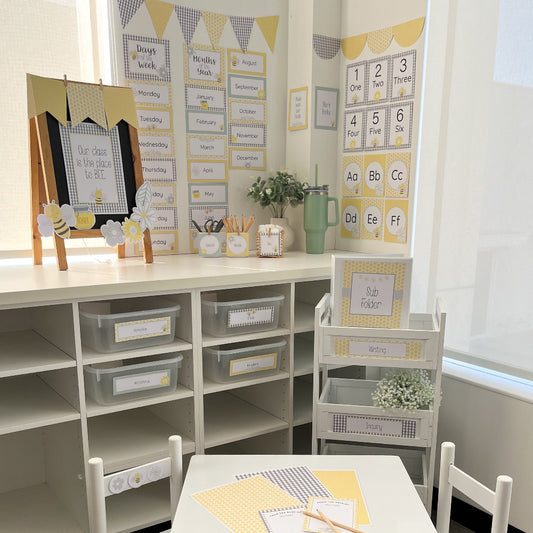 Yellow and Grey bee themed Classroom setup with educational materials and decor on a white desk.