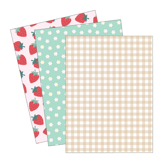 Three sheets of patterned paper with strawberry, flower, and checkered designs on a white background.