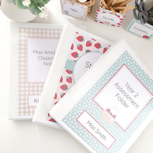 Teacher folders with personalised labels on a white surface