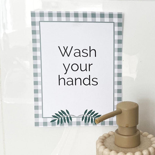 Small printable sign on a white wall next to sink. 