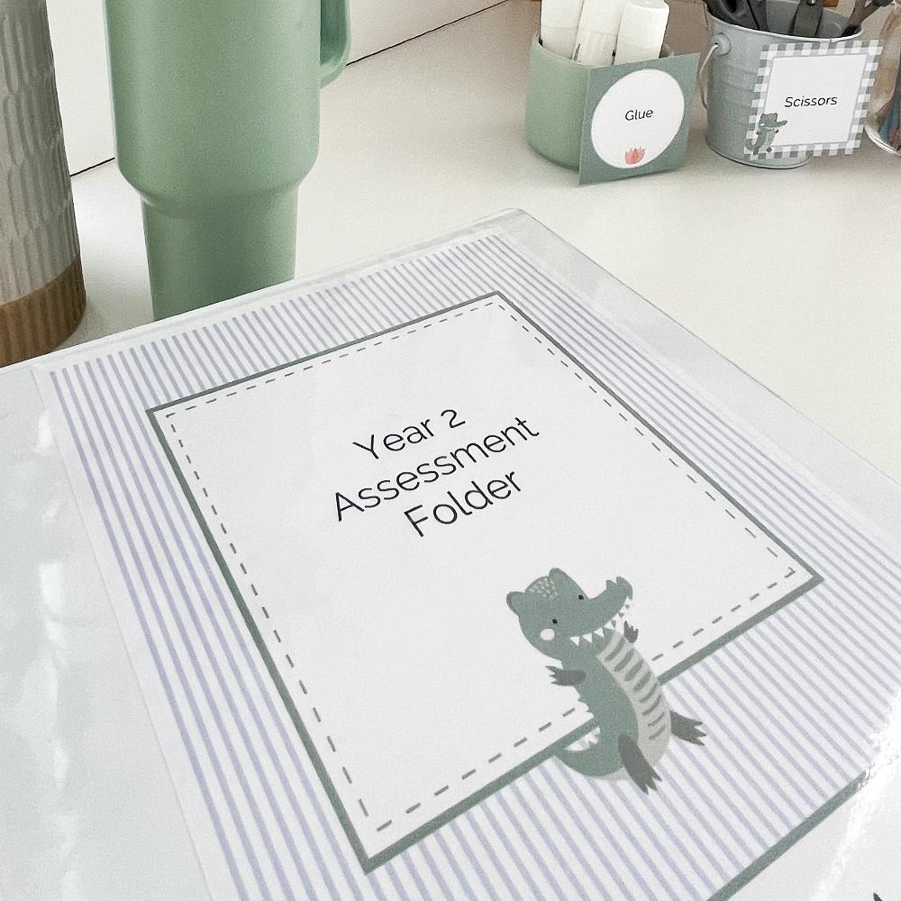 Classroom binder book covers in a Crocodile Theme on a desk.