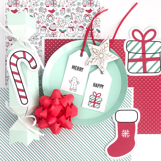Collection of Christmas-themed paper cutouts including a wreath, candy cane, bow, and tags on a patterned background.
