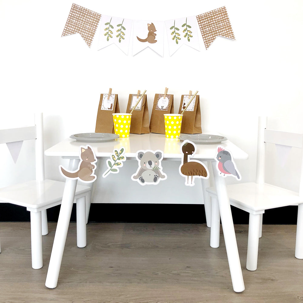 Party set in in an Australian Theme with a white table and chairs. There are cute Australian Animals Stuck on the table. 