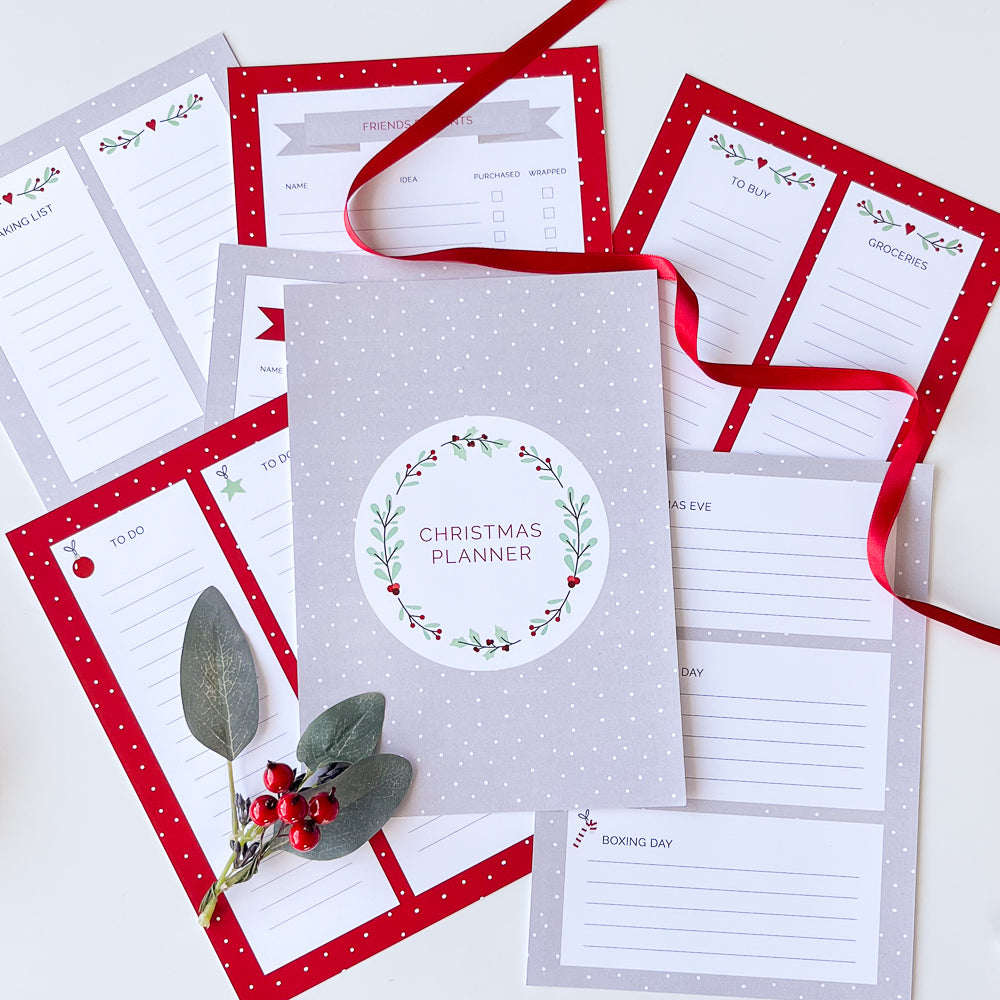 Christmas planner printable in red and grey spread out on white table